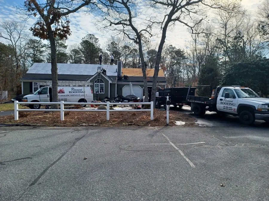 Pannoni Roofing crew and trucks on site while a ranch house is being re-roofed